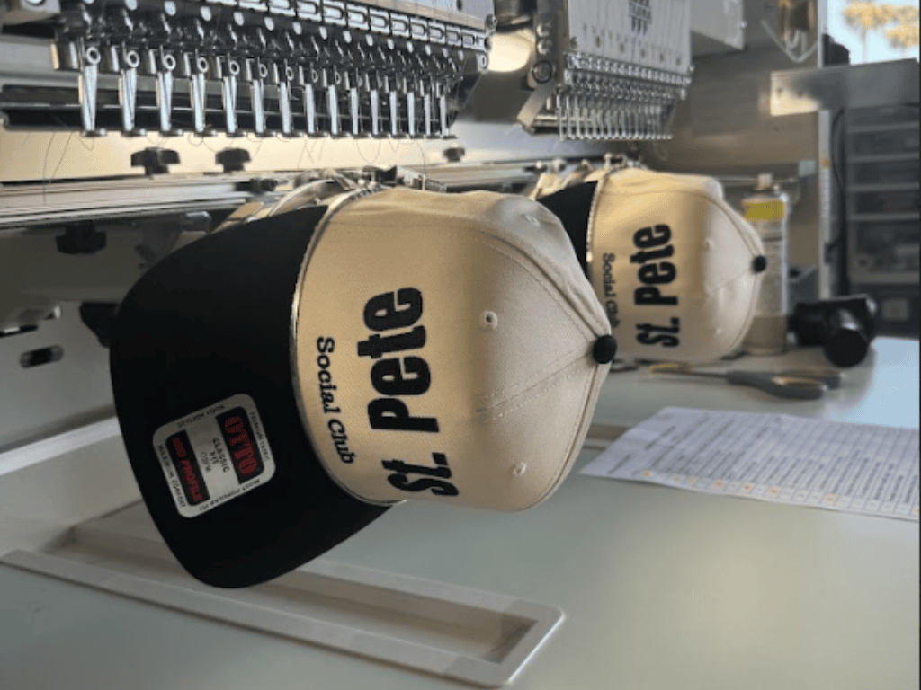 custom hats being embroidered on commercial embroidery machine during production process